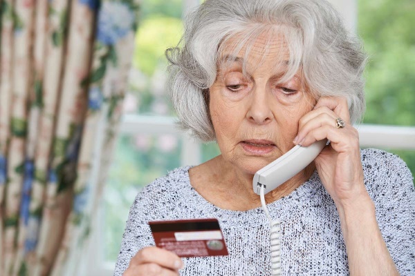 Старшая женщина с картой общается по телефону